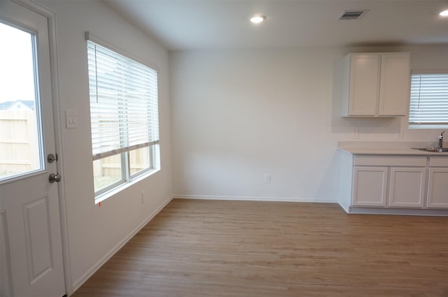 unfurnished dining area featuring sink and light wood-type flooring