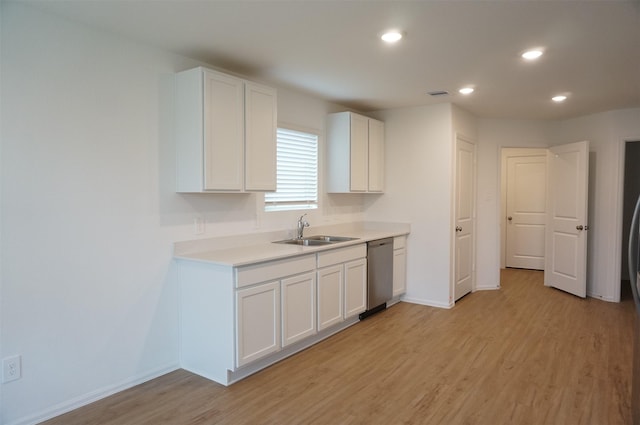 kitchen featuring sink, stainless steel dishwasher, white cabinets, and light wood-type flooring