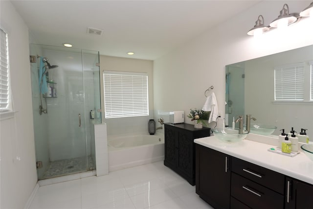 bathroom with vanity, tile patterned floors, and plus walk in shower