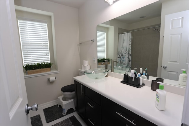 bathroom with a shower with curtain, vanity, toilet, and a wealth of natural light