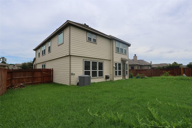 back of house with cooling unit and a lawn