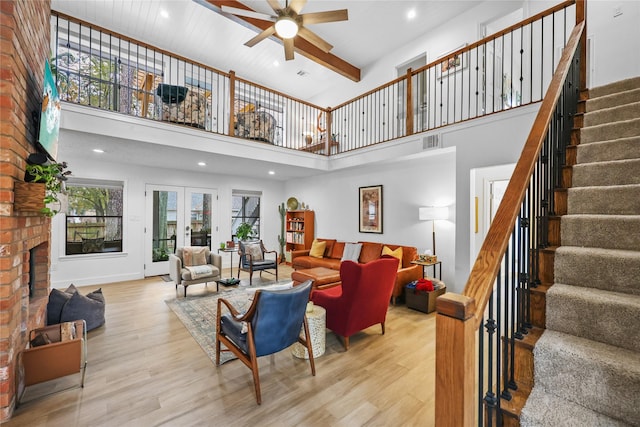 living area with french doors, a fireplace, wood finished floors, and visible vents