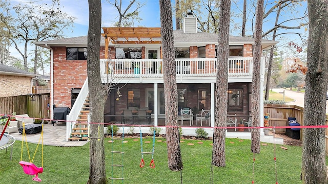 rear view of house featuring a yard, brick siding, a chimney, and a sunroom