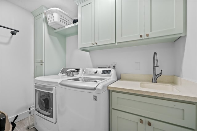 laundry room featuring cabinet space, washing machine and dryer, and a sink