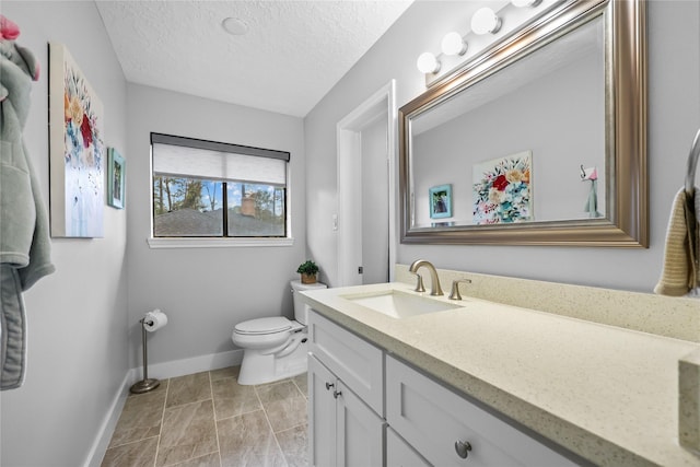 bathroom with a textured ceiling, tile patterned flooring, toilet, vanity, and baseboards