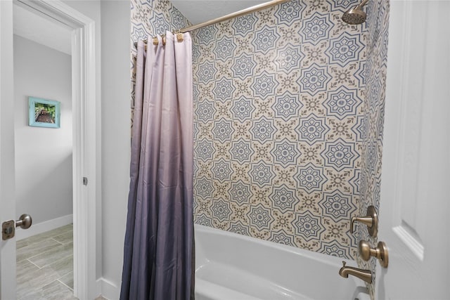 full bath featuring shower / tub combo and baseboards