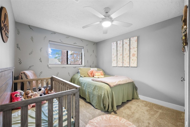 carpeted bedroom with ceiling fan, baseboards, and a textured ceiling