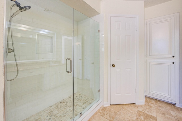 bathroom with a shower with door