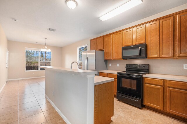11430 Alcott Dr, Montgomery, TX 77356 - kitchen featuring a center island with sink, an inviting chandelier, light tile patterned flooring, black appliances, and hanging light fixtures