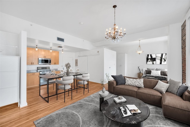 living room with a chandelier and light hardwood / wood-style floors