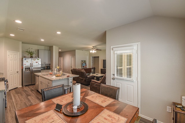 dining area featuring ceiling fan, lofted ceiling, sink, and dark hardwood / wood-style flooring