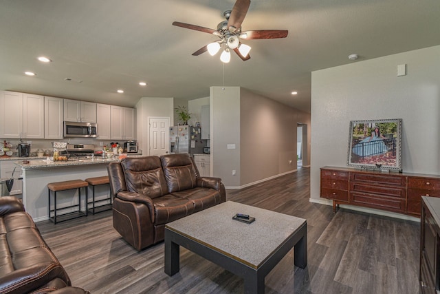 living room with dark wood-type flooring and ceiling fan