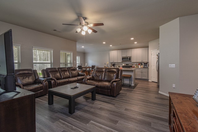 living room with dark hardwood / wood-style floors and ceiling fan