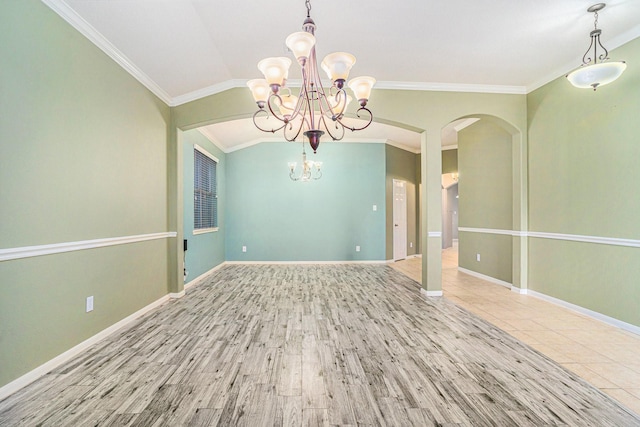 spare room featuring an inviting chandelier, ornamental molding, wood-type flooring, and lofted ceiling
