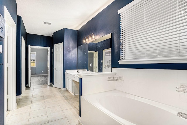 bathroom featuring vanity, a bath, and tile patterned flooring