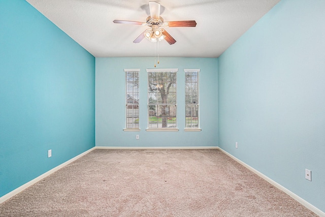 carpeted spare room with ceiling fan