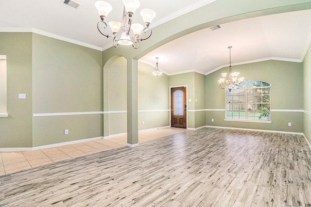 interior space with vaulted ceiling, ornamental molding, light wood-type flooring, and a notable chandelier
