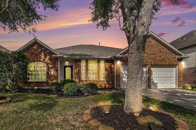 view of front of home with a garage and a lawn