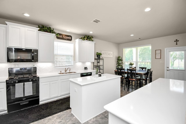 kitchen featuring white cabinets, a center island, sink, and black appliances