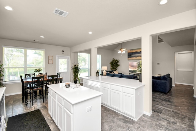 kitchen featuring a kitchen island, white cabinets, and ceiling fan