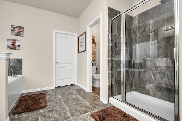 bathroom featuring a shower with shower door and toilet