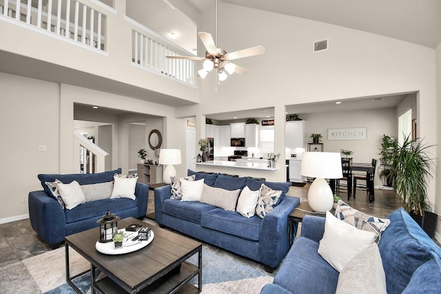 living room featuring a towering ceiling and ceiling fan