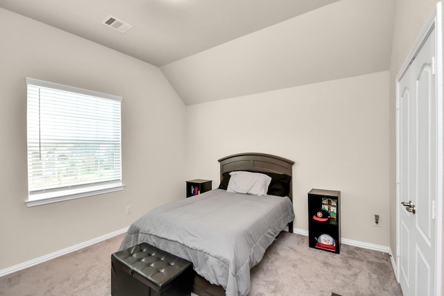 bedroom featuring lofted ceiling and light carpet