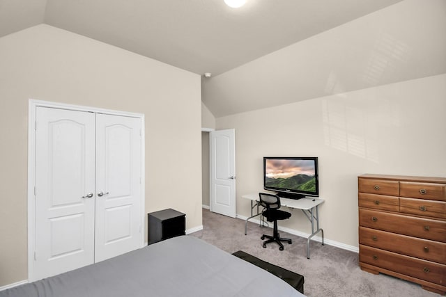 carpeted bedroom with lofted ceiling and a closet