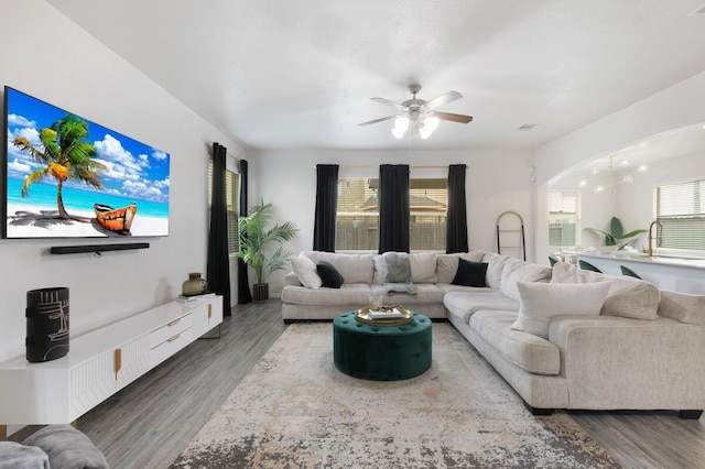 living room with dark hardwood / wood-style floors and ceiling fan