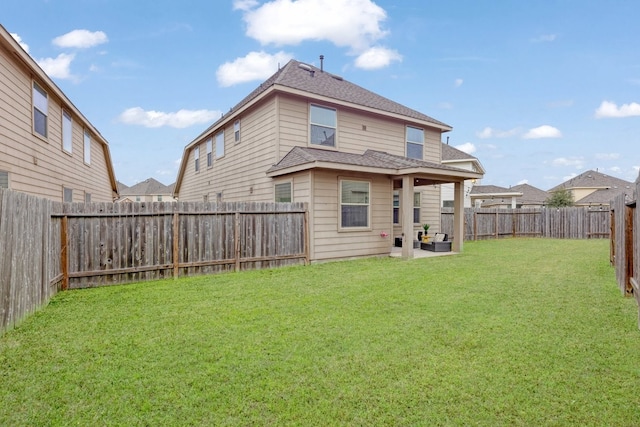 rear view of house featuring a patio and a lawn