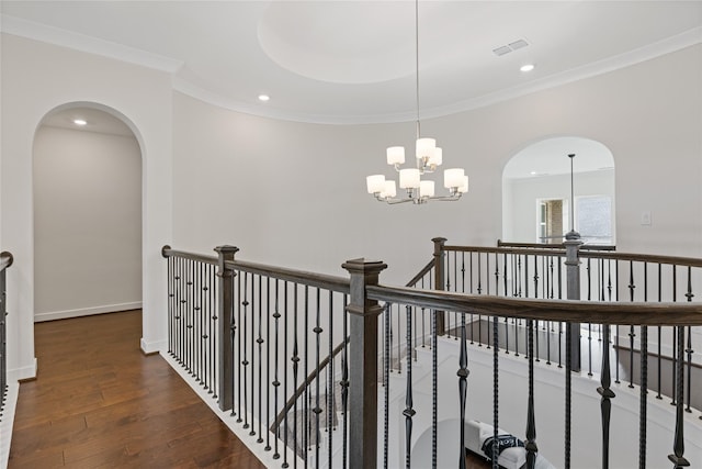 hallway with crown molding, dark hardwood / wood-style flooring, and an inviting chandelier