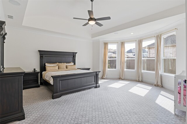 bedroom with a ceiling fan, a tray ceiling, carpet flooring, and visible vents