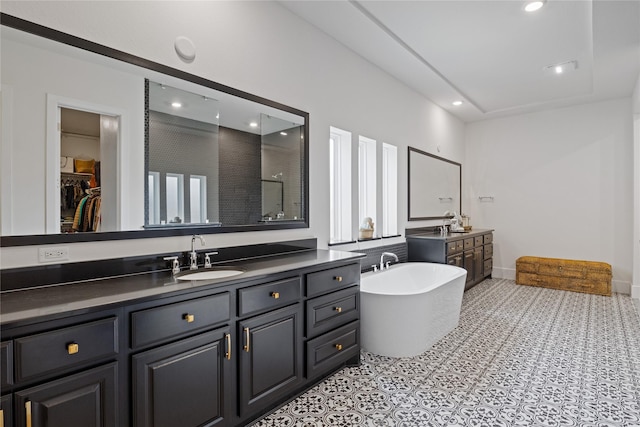 full bath with a freestanding tub, walk in shower, two vanities, a sink, and recessed lighting