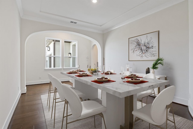 dining space featuring ornamental molding and dark hardwood / wood-style floors