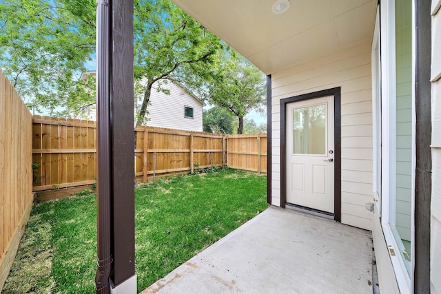 doorway to property with a lawn and a patio area