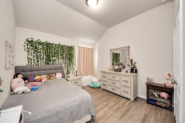 bedroom featuring light hardwood / wood-style floors and vaulted ceiling