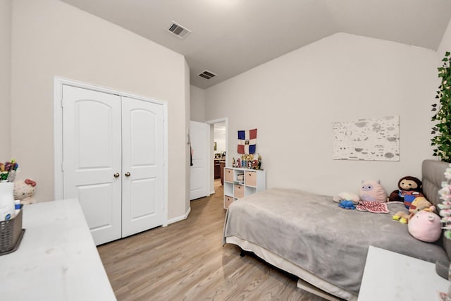 bedroom with vaulted ceiling, a closet, and light wood-type flooring