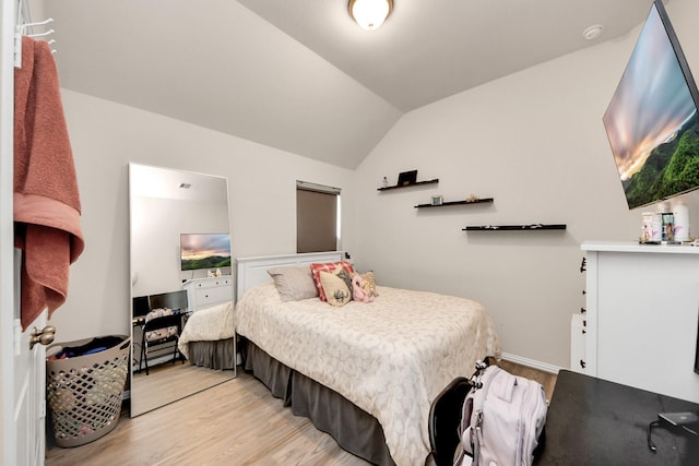 bedroom with lofted ceiling and light hardwood / wood-style flooring