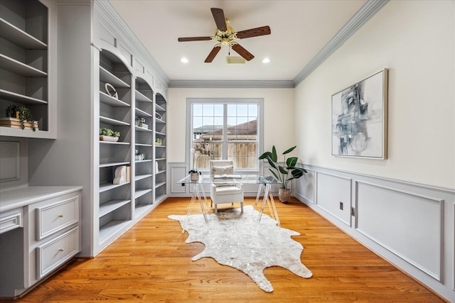 home office featuring built in shelves, ceiling fan, ornamental molding, and light hardwood / wood-style flooring