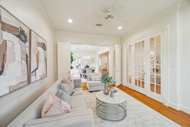 living room with crown molding, wood-type flooring, french doors, and ceiling fan