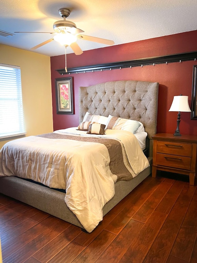 bedroom with dark wood-style flooring, visible vents, and a ceiling fan