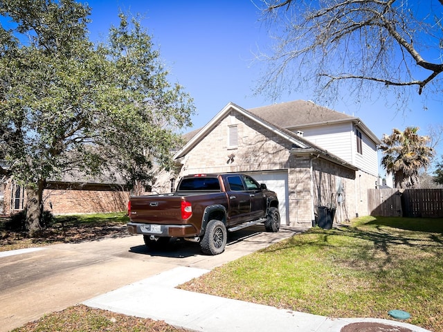 view of side of property with driveway, a garage, a lawn, fence, and brick siding