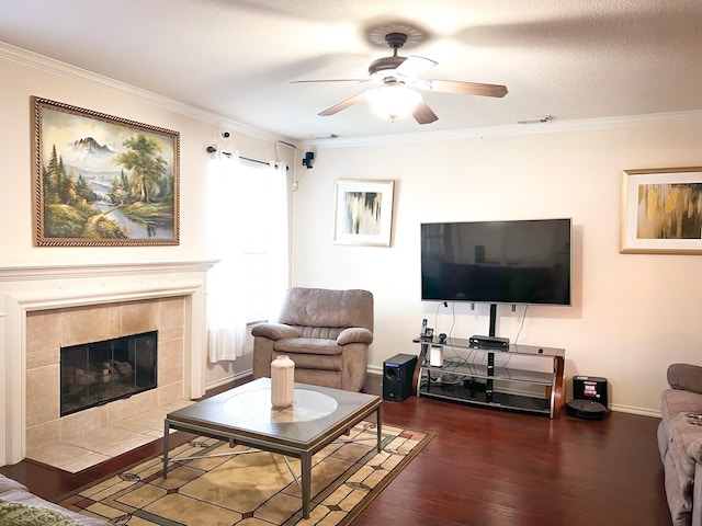 living room with dark wood-style floors, ornamental molding, a fireplace, and a ceiling fan