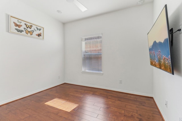 unfurnished room with a skylight and dark hardwood / wood-style floors