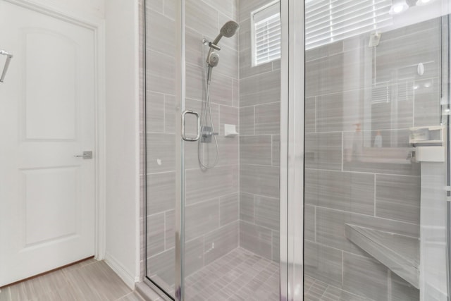 bathroom featuring a shower with door