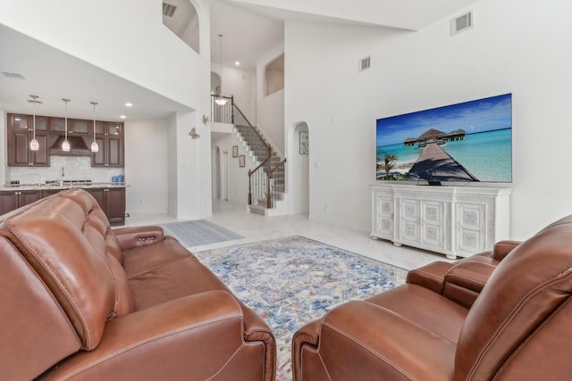 living room featuring sink and a towering ceiling