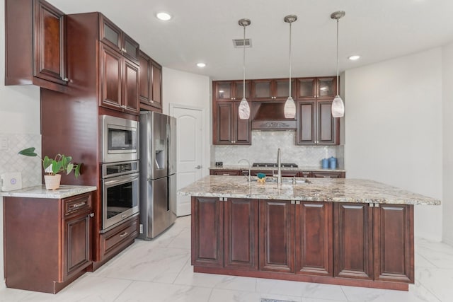 kitchen with sink, pendant lighting, custom range hood, stainless steel appliances, and light stone countertops