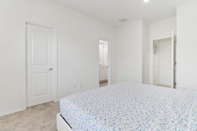 bedroom with light carpet and connected bathroom