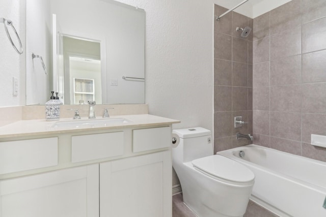 full bathroom featuring tiled shower / bath combo, vanity, and toilet