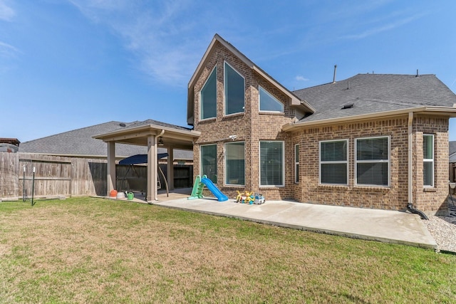 back of house featuring a patio area and a lawn